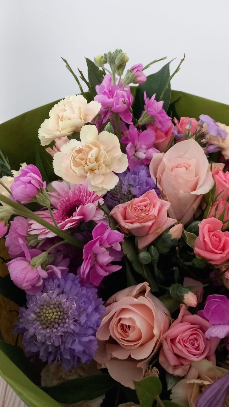 Romantisch boeket met roze rozen, anjers en scabiosa in roze en violet