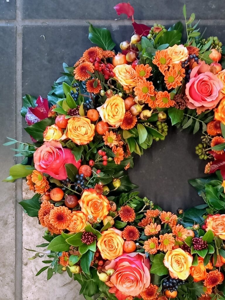 Detail van een herfstkrans met seizoensbloemen, gemaakt door Atelier Odiel in Kortrijk.