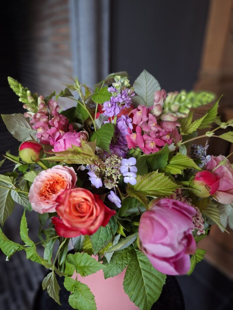 Seizoensboeket in een roze vaas, gemaakt door Atelier Odiel in Kortrijk.